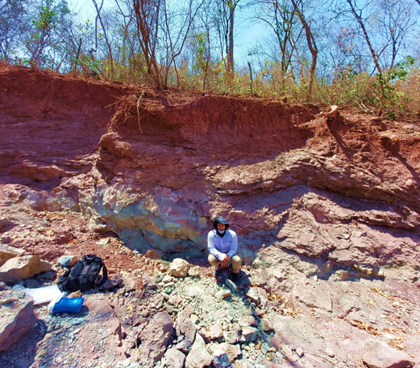 A person sitting on a rocky hill

Description automatically generated with low confidence